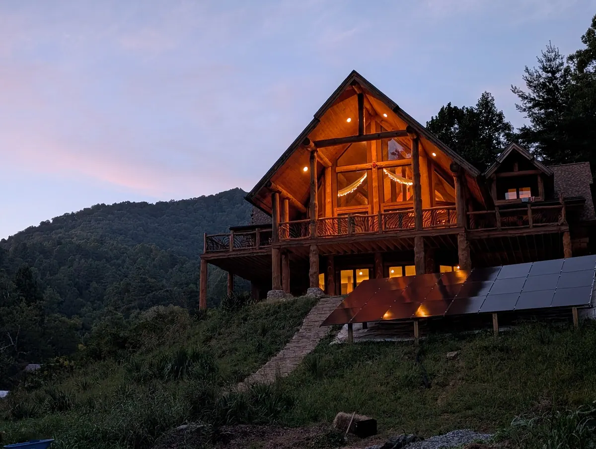 The main lodge at Love Song on our first evening, its windows glowing against the mountains