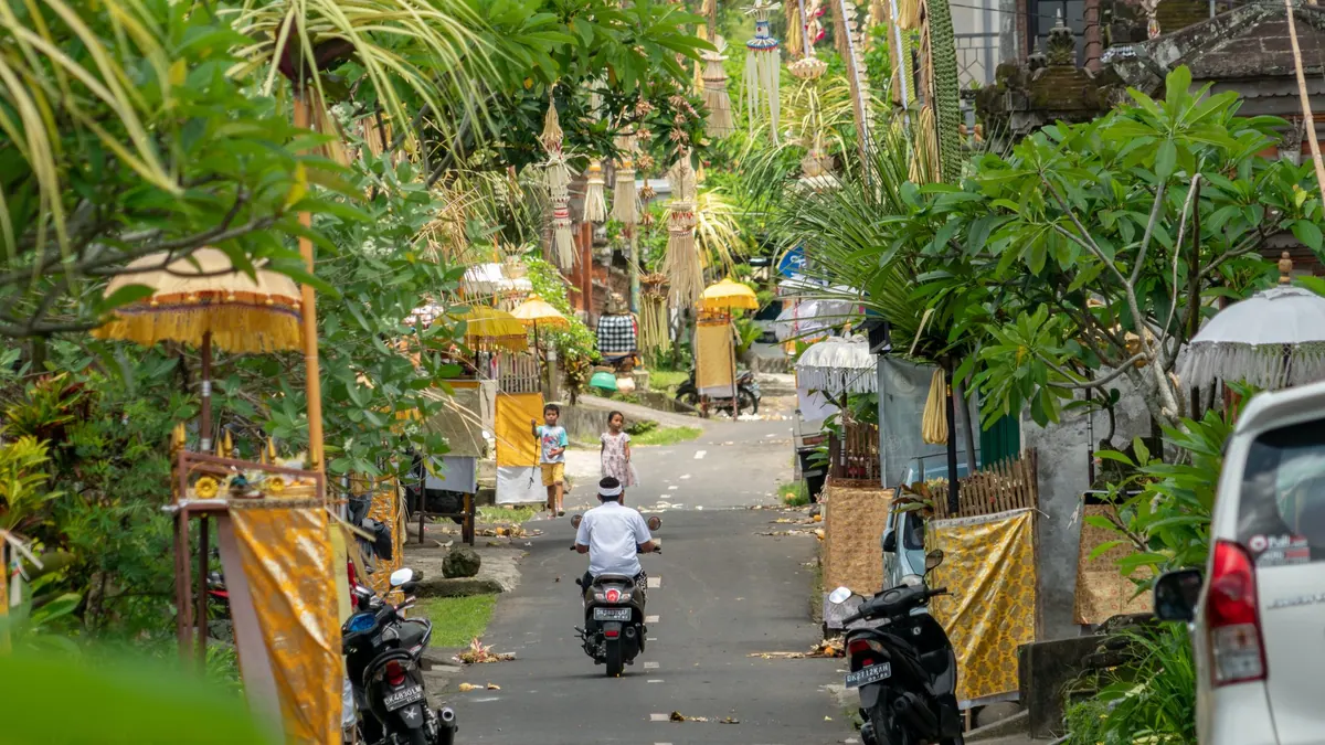 Scooters and shopfronts on a Bali street in the morning