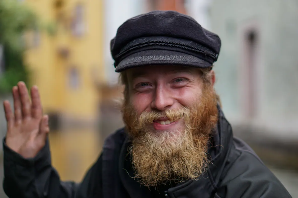A bearded boatman smiling from a canal boat in Colmar