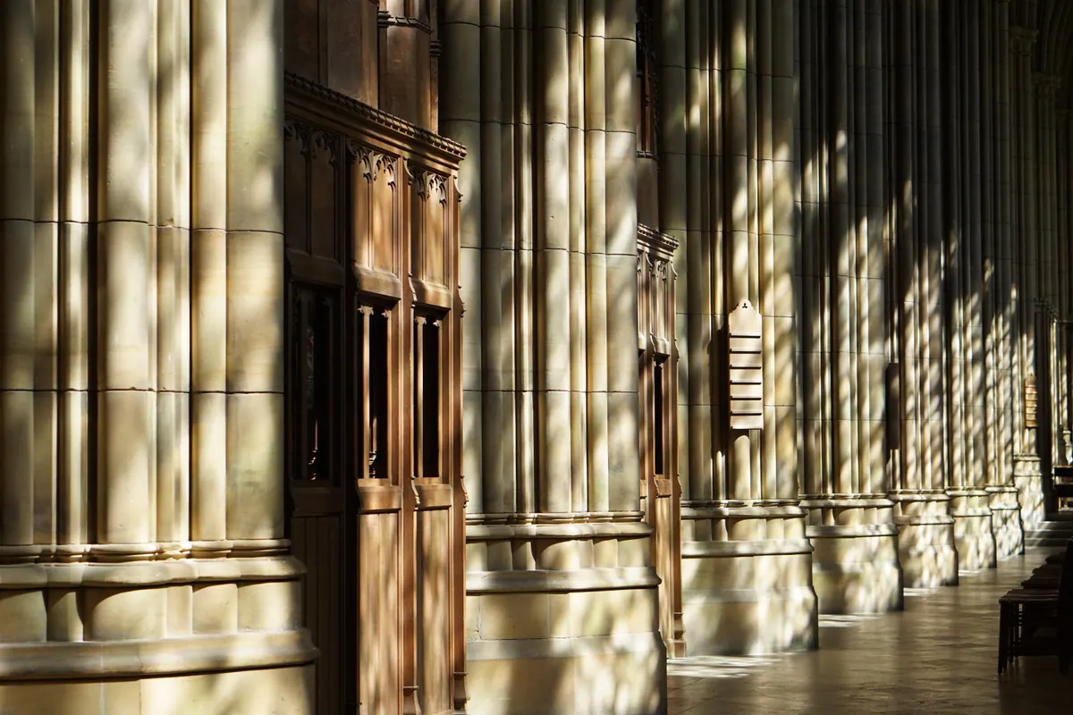 Bands of late light and shadow crossing an old cathedral wall and doorway