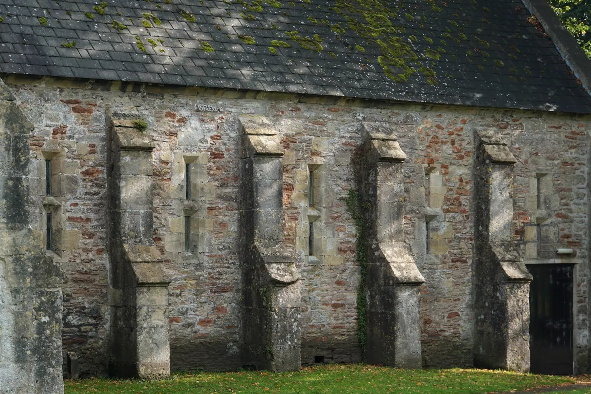Buttresses and moss along the weathered wall of an old English church