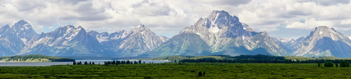 The jagged Teton Range rising in a wide panorama beyond the valley