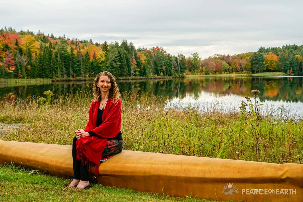A woman in red beside a still autumn lake, Vermont
