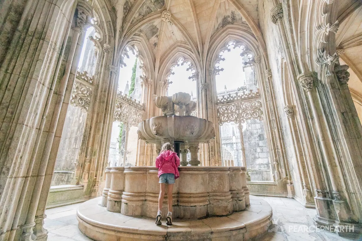 A child dwarfed by the soaring Gothic cloister of Batalha, Portugal