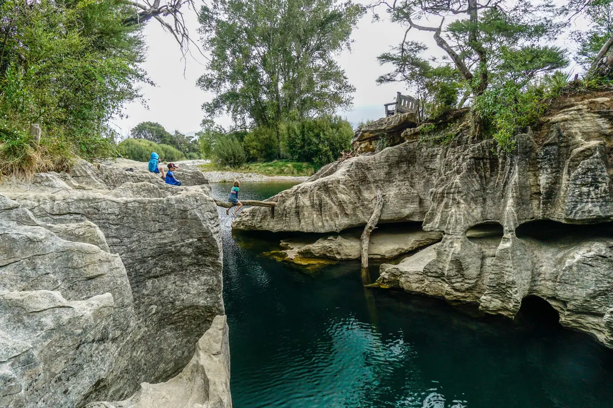 Swimmers in a turquoise quarry pool near Tākaka, New Zealand