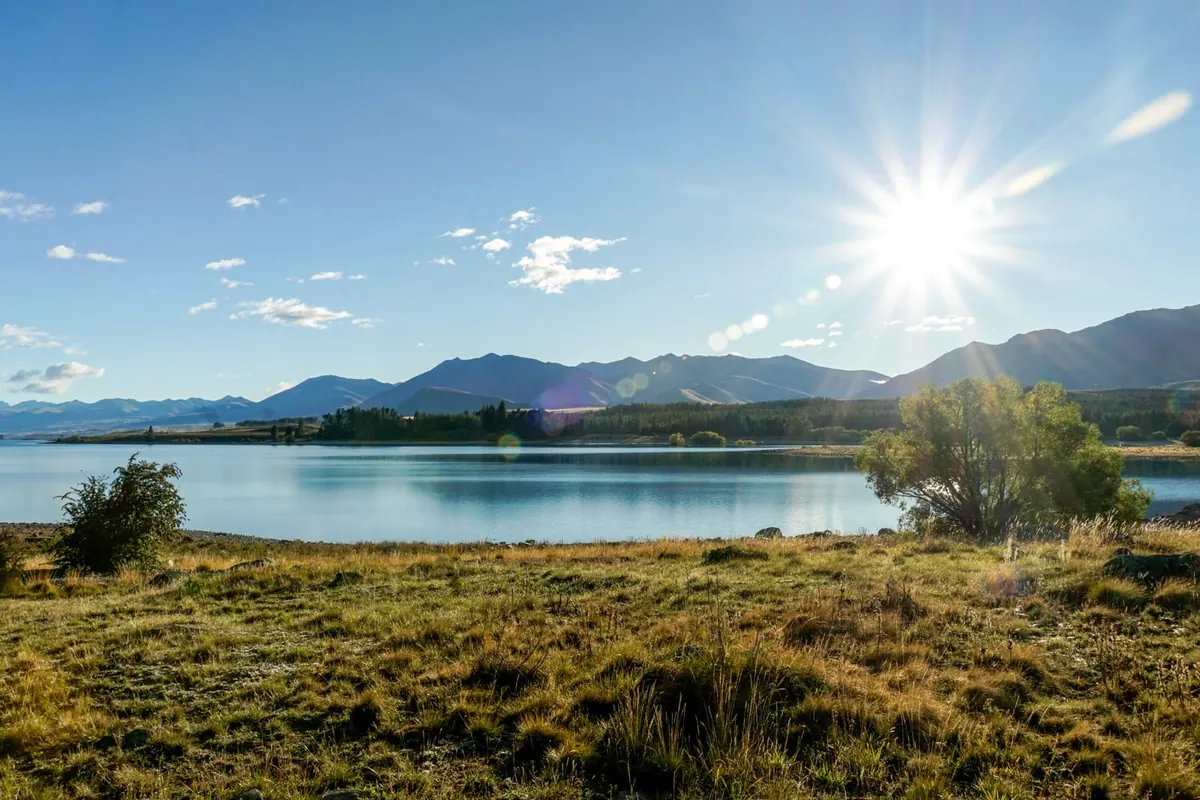 A sunstar bursting over Lake Tekapo, New Zealand